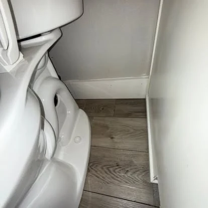 Detailed bathroom floor and hard-to-reach area beside the toilet