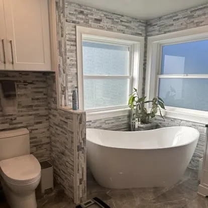 Detailed bathroom with clean tile, windows, fixtures, and freestanding tub