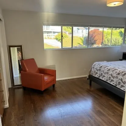 Clean bedroom with polished hardwood floors and tidy surfaces