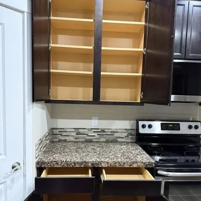 Clean kitchen cabinets, drawers, backsplash, and countertop