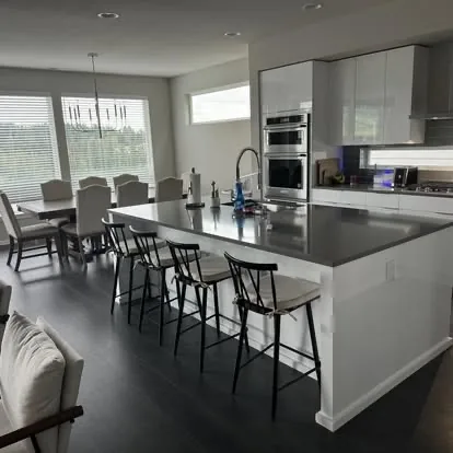 Clean modern kitchen and dining area with polished island and floors