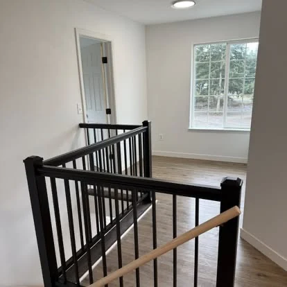 Clean stair landing, railing, walls, and flooring